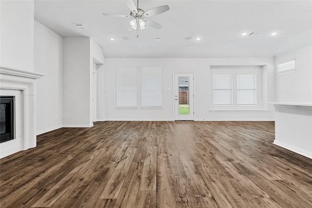 unfurnished living room featuring a glass covered fireplace, visible vents, recessed lighting, and wood finished floors