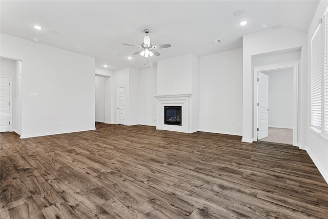 unfurnished living room featuring wood finished floors, a glass covered fireplace, and recessed lighting