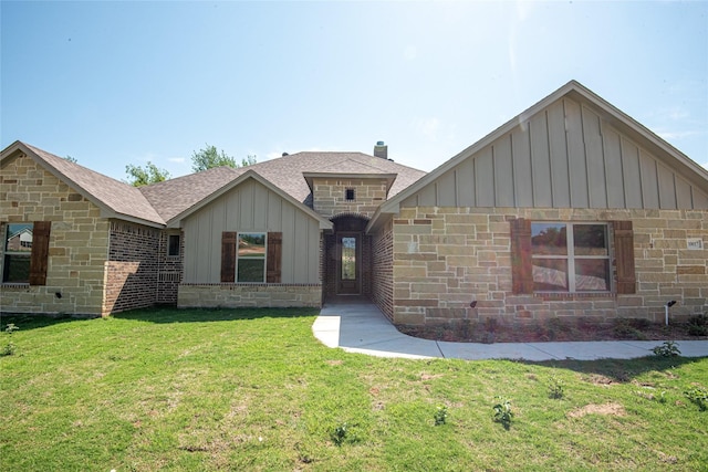 single story home featuring stone siding, a shingled roof, board and batten siding, and a front yard