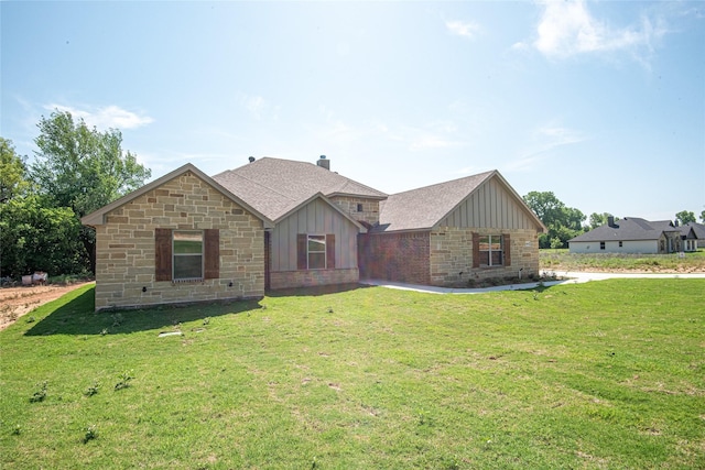 view of front facade featuring a shingled roof, a chimney, a front lawn, and board and batten siding