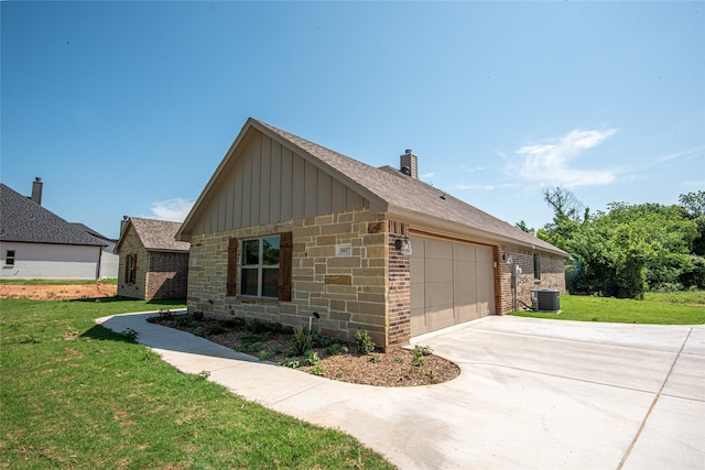 view of side of home featuring a yard, board and batten siding, an attached garage, and driveway