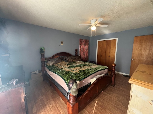 bedroom featuring a textured ceiling, ceiling fan, wood finished floors, and baseboards