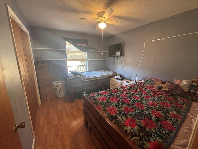 bedroom featuring a textured ceiling, wood finished floors, and a ceiling fan