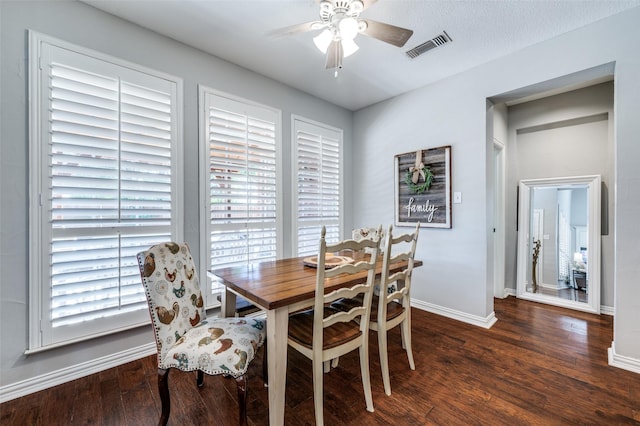 dining space with a ceiling fan, visible vents, baseboards, and wood finished floors