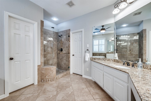 bathroom featuring ceiling fan, vanity, a shower stall, and visible vents