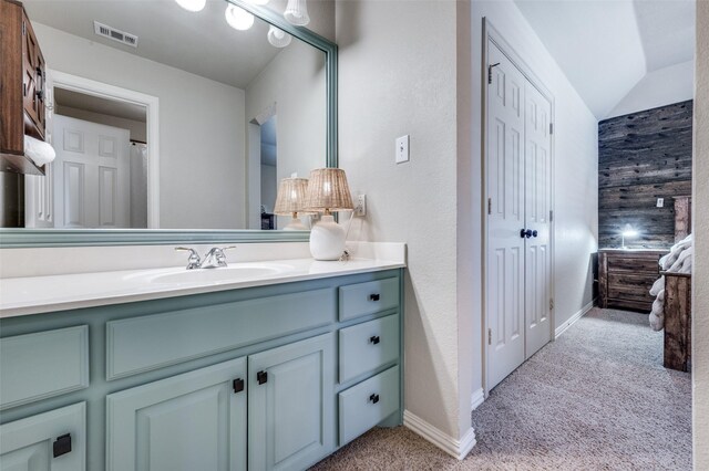 full bath featuring baseboards, visible vents, vaulted ceiling, and vanity