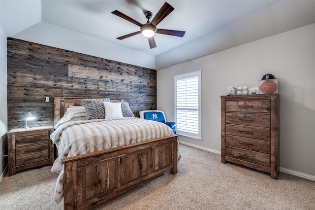 bedroom featuring lofted ceiling, wood walls, baseboards, and light colored carpet