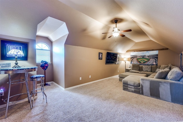 carpeted home theater room with vaulted ceiling, ceiling fan, a textured ceiling, and baseboards