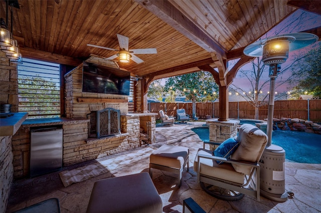 view of patio with a fenced in pool, a fenced backyard, an outdoor kitchen, and a ceiling fan