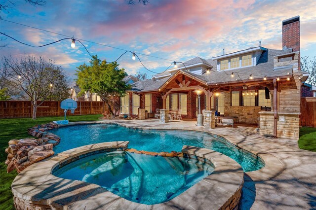 view of pool featuring a fenced backyard, a pool with connected hot tub, and a patio