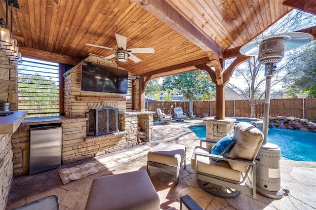 view of patio featuring a fenced in pool, a fireplace, area for grilling, a ceiling fan, and a fenced backyard