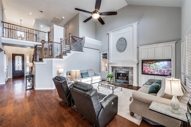 living area with high vaulted ceiling, dark wood finished floors, stairway, and baseboards