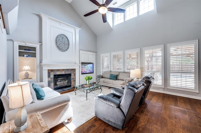 living area with a fireplace, wood-type flooring, visible vents, ceiling fan, and high vaulted ceiling