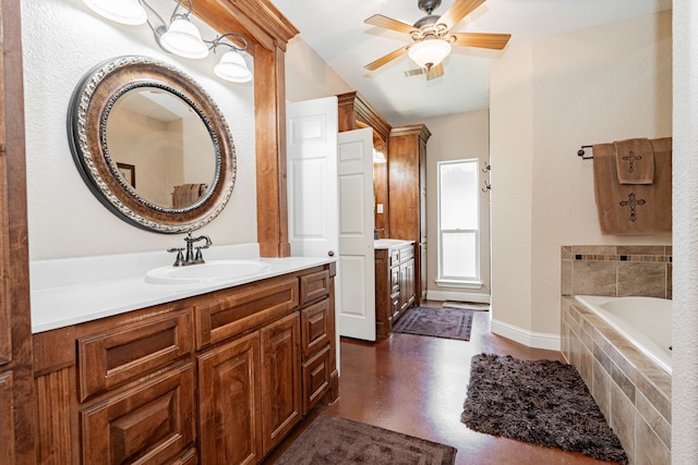 bathroom with baseboards, a ceiling fan, concrete flooring, vanity, and tiled tub