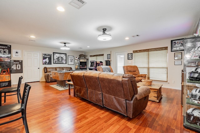 living area with recessed lighting, visible vents, baseboards, and wood finished floors