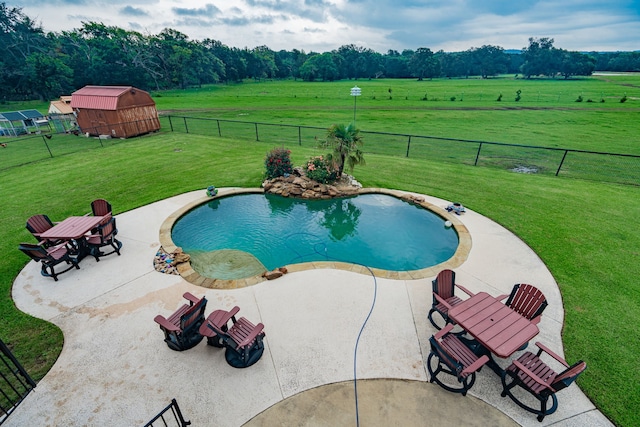 view of pool featuring a rural view, a lawn, a fenced backyard, and a fenced in pool