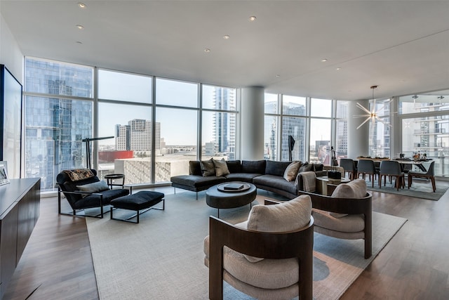 living room featuring a view of city, floor to ceiling windows, and wood finished floors