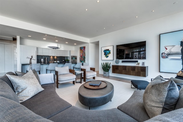 living area with light wood-type flooring and recessed lighting