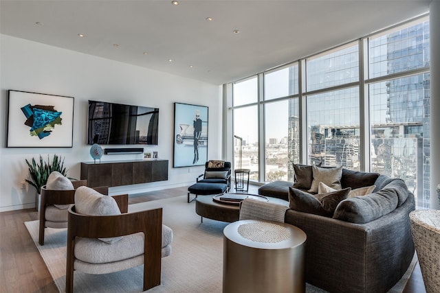 living room featuring expansive windows, recessed lighting, baseboards, and wood finished floors