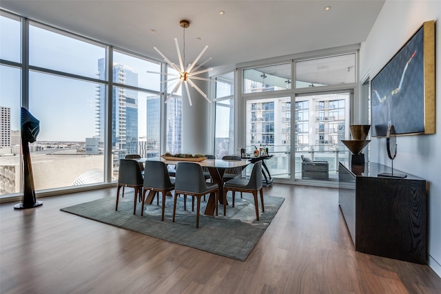 dining space featuring plenty of natural light, expansive windows, a chandelier, and wood finished floors