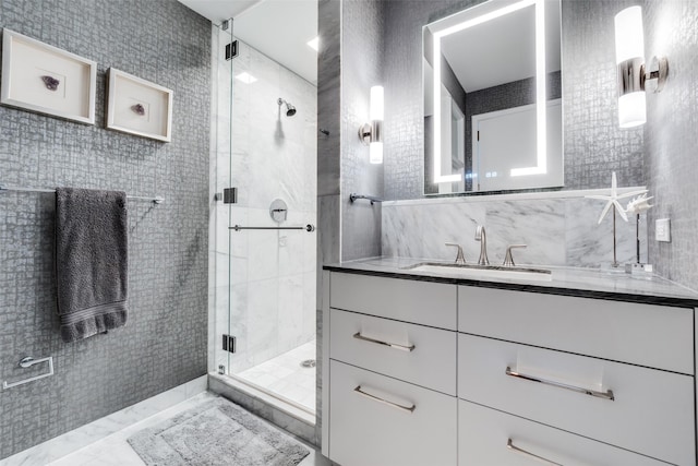 full bathroom with a stall shower, tile walls, and vanity