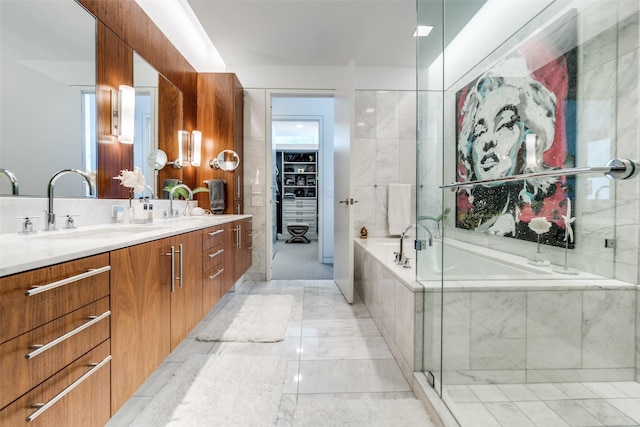 full bathroom featuring double vanity, a garden tub, marble finish floor, and a sink