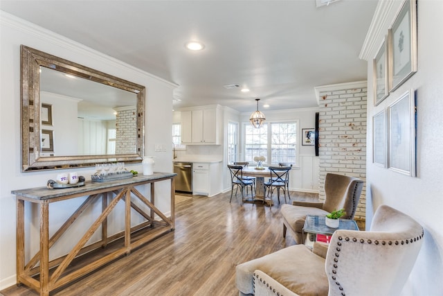 living room with light wood-style floors, crown molding, and recessed lighting