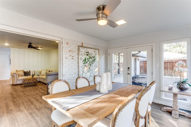 dining area with french doors, ceiling fan, and light wood-style flooring