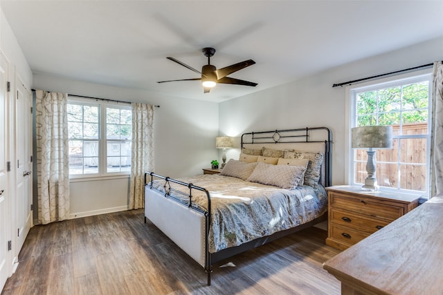 bedroom featuring dark wood-type flooring, a ceiling fan, and baseboards