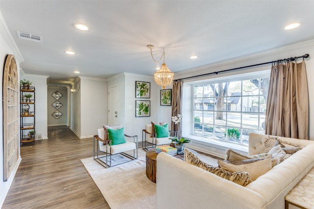 sitting room with recessed lighting, visible vents, crown molding, and wood finished floors