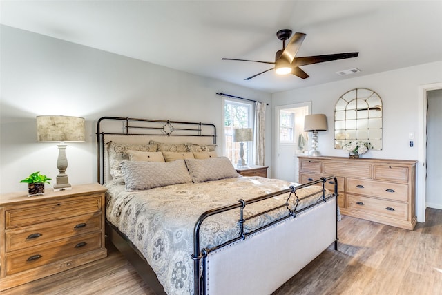 bedroom featuring light wood finished floors, ceiling fan, and visible vents