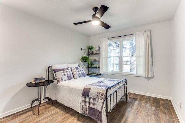 bedroom featuring ceiling fan, baseboards, and wood finished floors