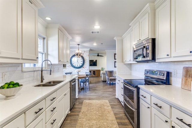 kitchen with stainless steel appliances, a sink, visible vents, and white cabinetry