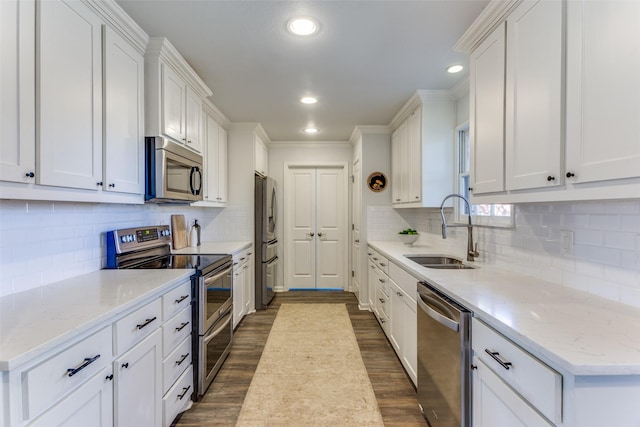 kitchen with white cabinetry, appliances with stainless steel finishes, dark wood-style flooring, and a sink