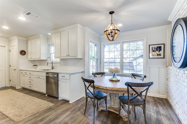 kitchen with visible vents, a wainscoted wall, light countertops, stainless steel dishwasher, and a sink