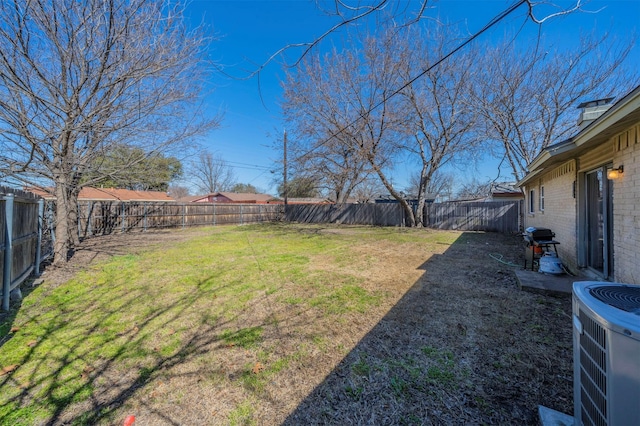 view of yard with central AC and a fenced backyard