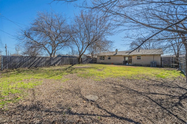 view of yard featuring a fenced backyard and central AC