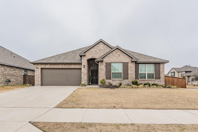 view of front facade featuring a garage, fence, concrete driveway, and brick siding