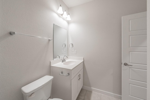 bathroom featuring toilet, vanity, baseboards, and tile patterned floors