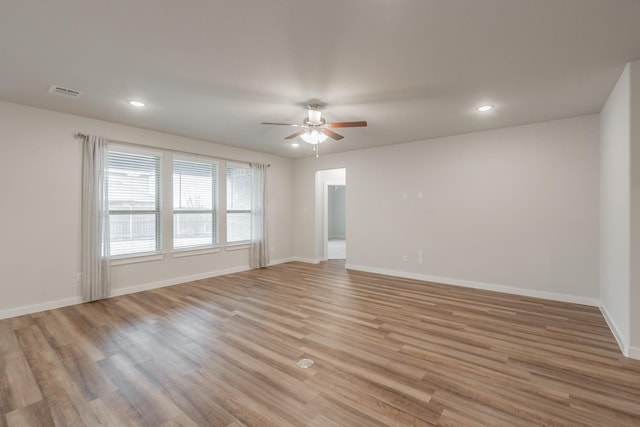 empty room featuring recessed lighting, visible vents, a ceiling fan, light wood-type flooring, and baseboards