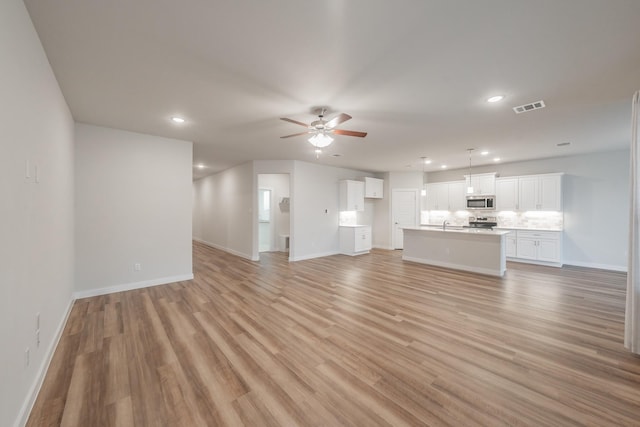 unfurnished living room with ceiling fan, light wood finished floors, visible vents, and recessed lighting