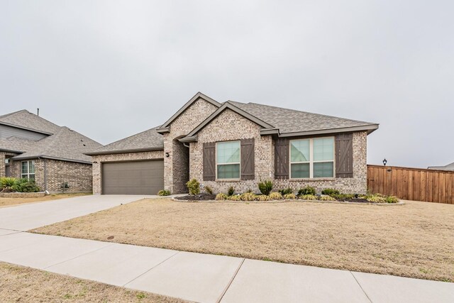 view of front of property featuring a garage, concrete driveway, brick siding, and a shingled roof