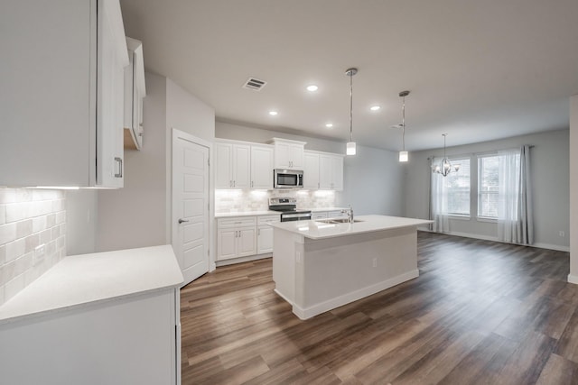 kitchen featuring visible vents, dark wood-style floors, stainless steel appliances, white cabinetry, and a sink