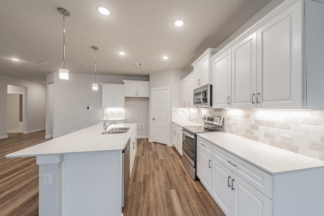 kitchen with light wood-style flooring, recessed lighting, stainless steel appliances, a sink, and backsplash