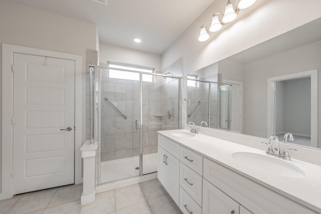 full bathroom with double vanity, a sink, a shower stall, and tile patterned floors