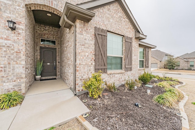 view of exterior entry featuring brick siding