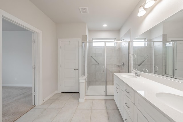 bathroom featuring a stall shower, tile patterned flooring, a sink, and visible vents