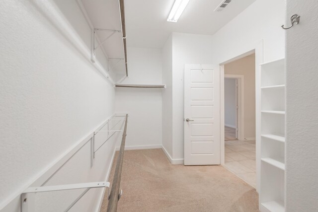 spacious closet featuring light carpet and visible vents