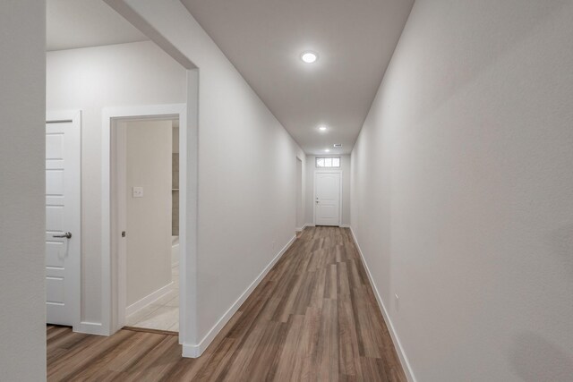 hall featuring recessed lighting, baseboards, and wood finished floors