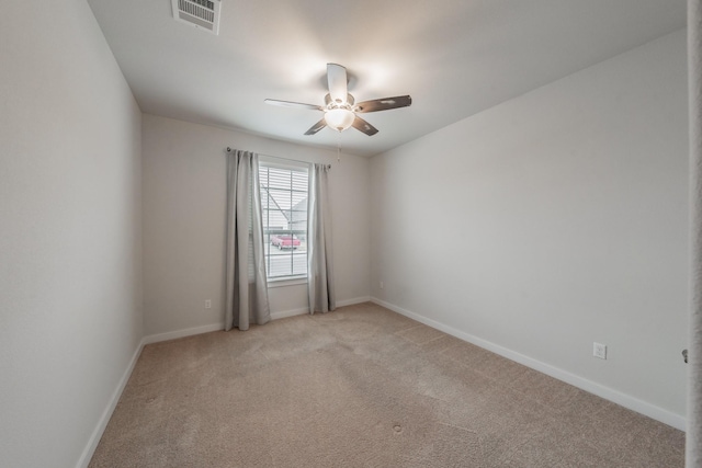 spare room with baseboards, a ceiling fan, visible vents, and light colored carpet